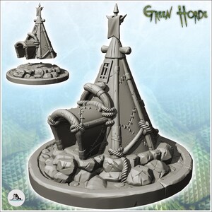 May include: A gray miniature model of a conical tent structure with a rounded entrance, rope detailing, and stitched panels, set on a circular rocky base. The text Green Horde is visible in the upper right corner of the image.