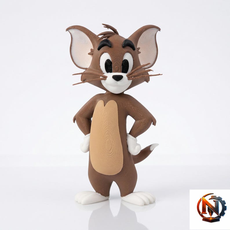 Op de afbeelding: Een 3D-geprint beeldje van het tekenfilmfiguur Jerry de muis. Het figuur is bruin met een beige buik, witte pootjes en witte binnenoren. Het heeft grote ogen, zwarte wenkbrauwen, een kleine zwarte neus en dunne snorharen aan beide kanten van het gezicht.