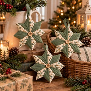 May include: Three quilted star ornaments featuring alternating panels of solid sage green fabric and cream fabric with a green holly leaf pattern. Each star has a central light wood button and a fabric loop for hanging, creating a festive look.
