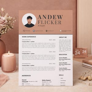 May include: A resume with the name ANDEW FLICKER, labeled as an AI Expert. The resume is on a desk with a candle, flowers, a coffee mug, and a pen. The date on the calendar is Tuesday, the 24th.