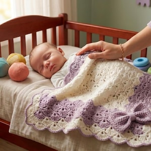 May include: A sleeping infant is covered by a white and lavender crocheted blanket featuring a scalloped edge and a decorative bow. The blanket has a textured, open-work pattern and is placed over the baby in a wooden crib with various toys nearby.