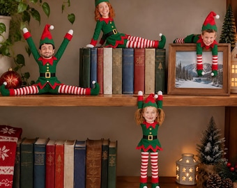May include: Four plush elf dolls with custom photo faces, wearing green tunics, black belts with gold buckles, and red and white striped leggings. The dolls are posed on and around wooden bookshelves, with one hanging vertically and others sitting.