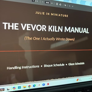 Pode incluir: Um documento digital intitulado The Vevor Kiln Manual, The One I Actually Wrote Down, de Julie in Miniature. O ecrã exibe secções para Handling Instructions, Bisque Schedule e Glaze Schedule num fundo castanho escuro com texto branco.