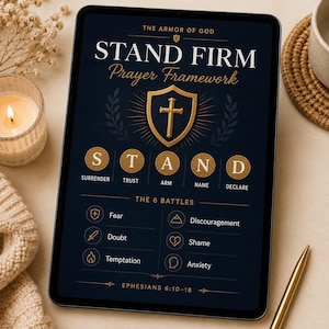 May include: A digital tablet displaying the Armor of God Stand Firm Prayer Framework. The dark blue screen features a gold shield with a cross, the acronym STAND with corresponding words, and a list of the 6 battles including Fear and Anxiety.