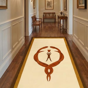 Puede incluir: Una alfombra pasillera rectangular con centro color crema y borde marrón oscuro. El diseño muestra dos serpientes entrelazadas de color óxido formando un círculo, con la silueta marrón oscuro de una persona sosteniendo una copa en el centro.