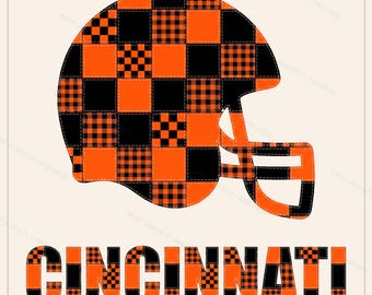 Könnte beinhalten: Eine grafische Darstellung eines Footballhelms und des Wortes CINCINNATI, beide mit einem Patchwork-Design aus einfarbigen orangefarbenen Quadraten und schwarz-orangefarbenen Karomustern mit sichtbaren Steppnähten auf hellem Grund.
