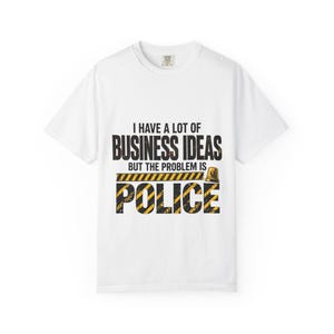 Peut inclure: Un t-shirt blanc à manches courtes avec le texte noir I HAVE A LOT OF BUSINESS IDEAS BUT THE PROBLEM IS, suivi du mot POLICE en grandes lettres jaunes et noires à rayures de signalisation, avec une petite icône de gyrophare jaune.