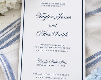 May include: A white wedding invitation with a navy blue border and text. The text reads "Kindly Save the Date for the Wedding of Taylor Jones and Alex Smith." Additional details include the date, time, and location: Castle Hill Inn, Newport, Rhode Island.