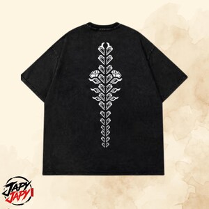 May include: A black short-sleeved t-shirt featuring a vertical, symmetrical white graphic print down the center back. The design consists of repeating geometric shapes arranged in a spine-like pattern, with two larger, distinct icons near the top.