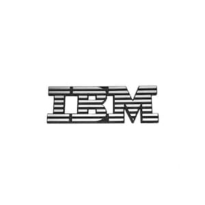 May include: A metallic IBM logo emblem featuring a series of horizontal black and silver stripes across the letters. The design consists of the letters I, B, and M, each constructed from stacked horizontal bars, creating a distinct striped pattern.