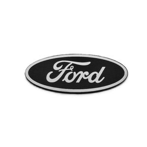 May include: Black oval patch with a white border and the word "Ford" in white script. The patch has a classic design, commonly associated with the Ford Motor Company.