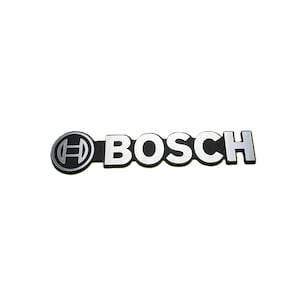 以下が含まれることがあります： シルバーとブラックのBoschロゴ。 「BOSCH」の文字はシルバーで、背景は黒です。 Boschの「O」は、中に様式化された「H」が入った円です。 ロゴは白い背景にあります。