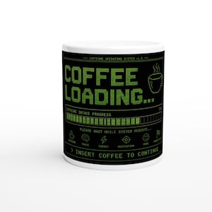 Könnte beinhalten: Ein weißer Keramikbecher mit einem schwarzen Rundum-Design, das grünen, verpixelten Text zeigt: CAFFEINE OPERATING SYSTEM v1.0, COFFEE LOADING, CAFFEINE INTAKE PROGRESS, PLEASE WAIT WHILE SYSTEM REBOOTS und INSERT COFFEE TO CONTINUE.