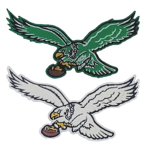 May include: Two embroidered patches featuring eagles in flight, each clutching a brown football in its talons. The top eagle is green with white and black details, while the bottom eagle is white with black outlines and a yellow beak.