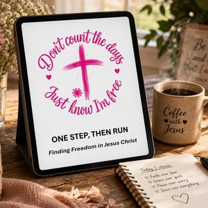 Peut inclure: Une tablette affichant un graphique avec une croix rose et le texte "Don't count the days, Just know I'm free", "ONE STEP, THEN RUN" et "Finding Freedom in Jesus Christ". L'écran montre également une liste de choix commençant par "Today I choose".