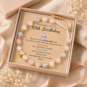 May include: A beaded bracelet with light pink, blue, and white stones, gold-tone spacers, and a gold heart charm, presented in a box with a card reading Crystal Wishes for Your 10th Birthday, listing rose quartz, aquamarine, and moonstone properties.