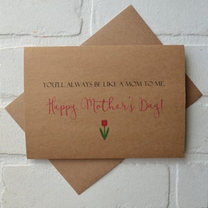 Może przedstawiać: Brązowa kartka z tekstem "You'll always be like a mom to me. Happy Mother's Day!" w czerwonych literach. Pod tekstem znajduje się czerwony tulipan z zieloną łodygą i liśćmi.