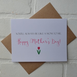 Może przedstawiać: Biała kartka z tekstem "You'll always be like a mom to me. Happy Mother's Day!" w r&oacute;żowym, ozdobnym piśmie. Pod tekstem znajduje się r&oacute;żowy tulipan z zieloną łodygą i liśćmi.
