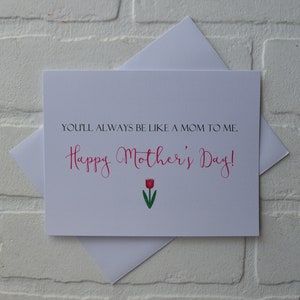 Może przedstawiać: Biała kartka z tekstem "You'll always be like a mom to me. Happy Mother's Day!" w r&oacute;żowym, ozdobnym piśmie. Pod tekstem znajduje się czerwony tulipan z zieloną łodygą.