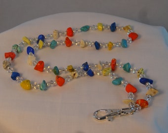 May include: A colorful beaded lanyard with a silver clasp. The beads are various shapes and sizes, including turquoise, red, yellow, blue, and white.