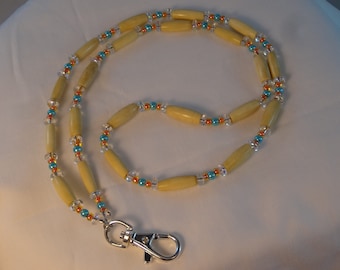 May include: A beige beaded lanyard with turquoise and orange beads and a silver swivel clasp.