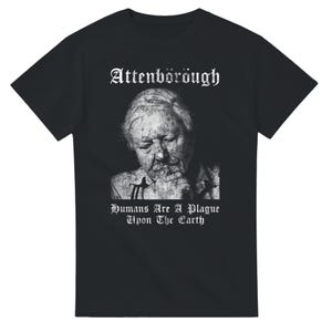 May include: A black short-sleeved t-shirt featuring a white graphic print of a person with their hand near their chin. Above the image is the text "Attenborough" and below the image is the text "Humans Are A Plague Upon The Earth" in a gothic font.
