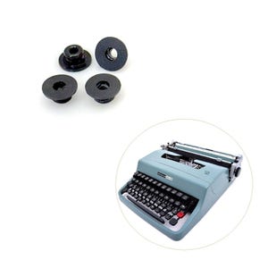 May include: Four black rubber grommets and a vintage light blue typewriter with black keys and a red return key. The typewriter is in a circular frame.