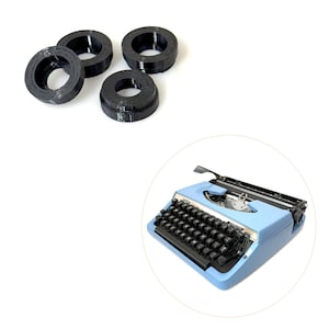 May include: Four black circular objects and a light blue typewriter with black keys. The typewriter is in a white circle. The objects appear to be spools or rings.