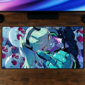 May include: A rectangular desk mat featuring a vibrant anime-style illustration of a character with light green hair and a mechanical glove, set against a background of multiple white skulls with pink accents, rendered in a bold, high-contrast graphic art style.