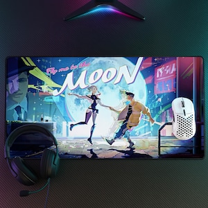 Puede incluir: Una alfombrilla de escritorio rectangular con una vibrante ilustración estilo anime de dos figuras bailando bajo una gran luna con el texto Fly me to the MOON. Unos auriculares negros con micrófono y un ratón gaming blanco perforado descansan.