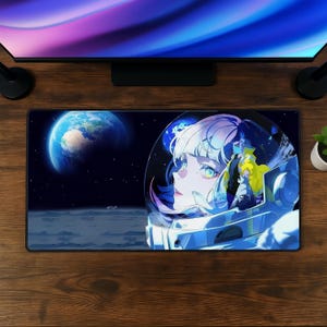 Può includere: Un tappetino da scrivania rettangolare con un'illustrazione a tema spaziale di un personaggio che indossa un casco da astronauta bianco. Lo sfondo mostra un cielo stellato, una vista della Terra e una superficie lunare. Il personaggio ha capelli chiari.