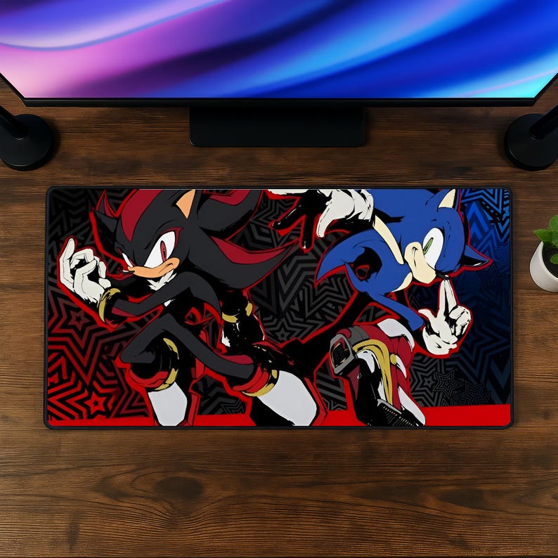 K&ouml;nnte beinhalten: Eine rechteckige Schreibtischunterlage mit einer grafischen Illustration der Charaktere Shadow the Hedgehog und Sonic the Hedgehog in einer dynamischen Pose. Der Hintergrund zeigt ein schwarz-rotes Sternenmuster mit kr&auml;ftigen Farben.