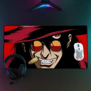 May include: A rectangular desk mat featuring a graphic illustration of a character with long black hair, a wide-brimmed red hat, and round orange-tinted glasses. The character has sharp teeth and a bullet in their mouth against a red background.
