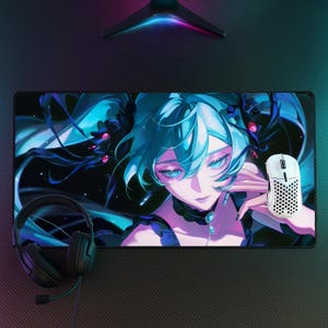 May include: A rectangular desk mat featuring a vibrant anime-style illustration of a character with flowing teal hair, bright blue eyes, and a dark choker. A white honeycomb-patterned computer mouse and black wired headphones rest on the mat surface.