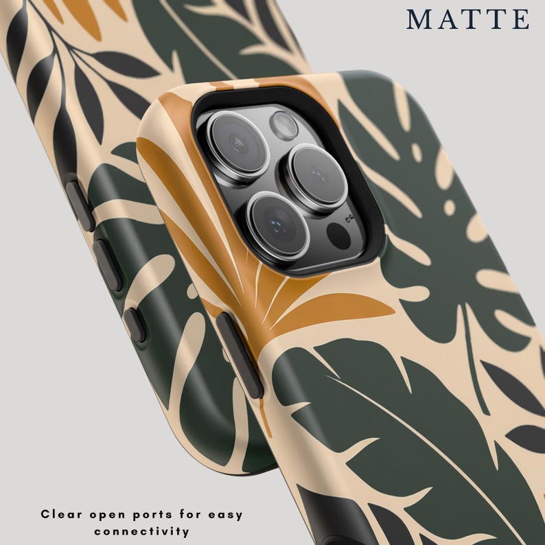 May include: A matte phone case featuring a botanical pattern of dark green and mustard yellow leaves on a beige background. The case has a black camera cutout and black side buttons. Text on the image reads MATTE and Clear open ports for easy connectivity.