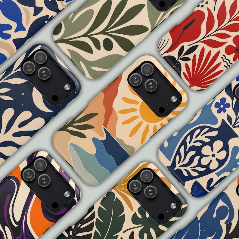 May include: A collection of smartphone cases featuring diverse graphic patterns including abstract foliage, a yellow sun over blue hills, red floral motifs, and blue vases with flowers. Each case has a black camera module with three lenses.