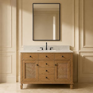 Puede incluir: Un mueble de baño de madera marrón claro con encimera de mármol blanco, un espejo rectangular con marco negro y un grifo negro. El mueble cuenta con dos armarios laterales con paneles de rejilla y cinco cajones centrales con pomos negros.