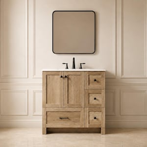 Puede incluir: Un mueble de baño de madera clara con encimera blanca, grifo central y un espejo cuadrado con marco negro fino. El mueble incluye dos puertas de armario, tres cajones apilados a la derecha y un cajón ancho en la parte inferior.