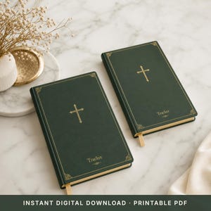 May include: Two dark green books with gold cross and border details. The word "Tracker" is printed on the bottom of the cover. Each book has a cream-colored ribbon bookmark. The books are on a marble surface.