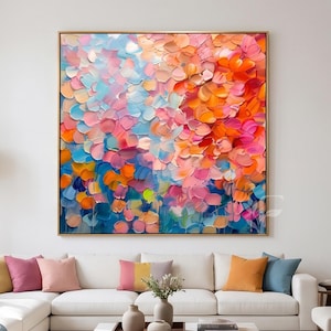 May include: A square canvas painting featuring thick, textured impasto brushstrokes in a vibrant palette of orange, pink, light blue, and yellow. The abstract composition displays layered, petal-like dabs of paint that create a sense of depth.