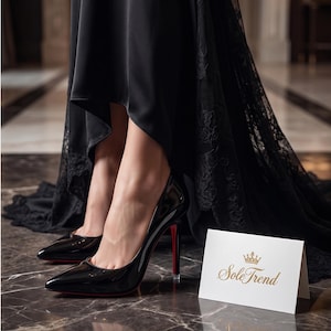 Puede incluir: Un par de zapatos de tac&oacute;n de charol negro con punta afilada y suela roja, combinados con un vestido de sat&eacute;n y encaje negro. Una tarjeta blanca doblada se encuentra cerca, con un icono de corona dorada y el texto SoleTrend en letras doradas.