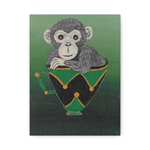 May include: A small monkey sits in a green and black teacup with gold accents. The monkey has a gray face and body with a white nose and chin.