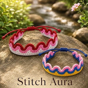 May include: Two handmade crochet bracelets with wavy edges. One features red, pink, and white yarn with a red cord. The other features blue, pink, and yellow yarn with a blue cord. The text Stitch Aura STUDIO 10 is visible at the bottom.