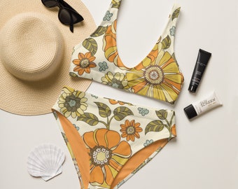 May include: A white and orange floral print bikini with a high-waisted bottom. The bikini is laid out on a white surface with a straw hat, sunscreen, and a seashell.