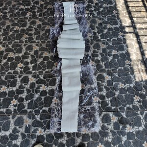 May include: A long, off-white python skin strip with a textured, scaled surface pattern, folded in multiple sections and partially encased in clear plastic packaging. The text GoPythonHouse is printed in white near the top of the skin.