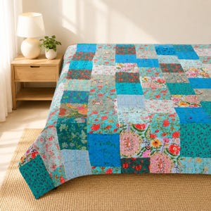 May include: A rectangular patchwork quilt featuring a variety of floral and geometric patterns in shades of blue, teal, green, and pink. The quilt is constructed from multiple fabric squares stitched together with visible running stitch details.