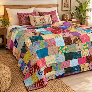 Puede incluir: Una colcha de retazos que presenta una variedad de cuadrados de tela coloridos con diversos patrones, incluyendo diseños florales, geométricos y abstractos en tonos azules, rosas, amarillos y verdes, colocada sobre una cama con almohadas blancas y estampadas.