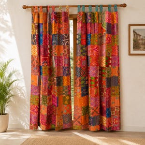 Peut inclure: Une paire de rideaux pleine longueur présentant un motif patchwork vibrant composé de nombreux panneaux de tissu carrés de diverses couleurs, notamment orange, rouge, rose, vert et bleu, suspendus à une tringle en bois par des pattes.