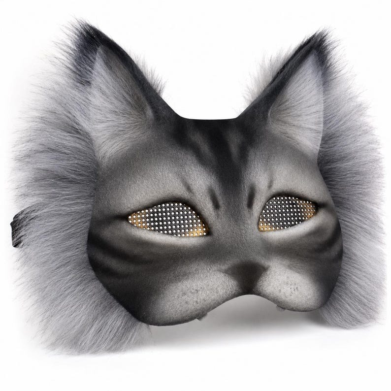 May include: A gray cat mask with a faux fur trim and detailed facial features. The eyes are designed with a grid of small, gold-colored dots. The mask has a black strap for securing it.