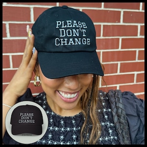 May include: A black baseball cap featuring the white embroidered text PLEASE DON'T CHANGE on the front crown. The cap has a structured front panel, a curved brim, and a button on top. A small circular inset shows the same cap on a plain background.